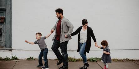 A family walking together consisting of a mother, father, son and daughter