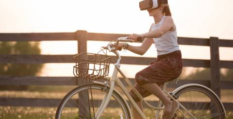 Girl wearing a vr box driving a bicycle