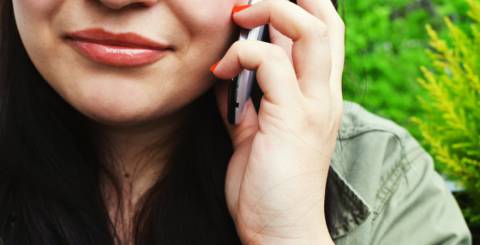 Bottom half of a woman's face while she is one the phone.