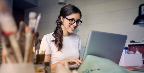 Women sitting at a table working on a laptop.