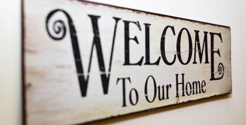 Wooden wall sign that reads 'welcome to our house'