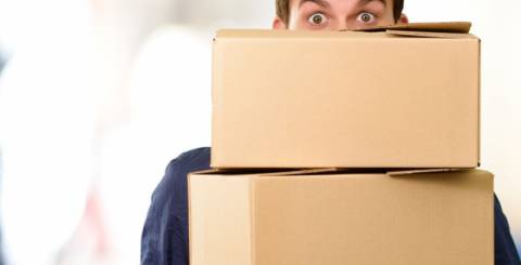 A man is holding cardboard moving boxes