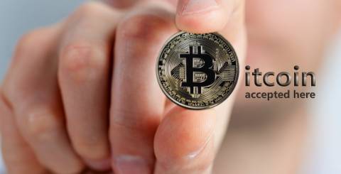 hand holding a bitcoin physical coin