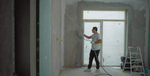 A working cleaning the wall with a pressure washing A working cleaning the wall with a pressure washing