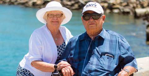 Senior couple sitting near beach shore