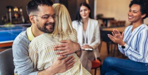Support group patients hug each other during the therapy session