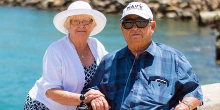 Senior couple sitting together Senior couple sitting near beach shore